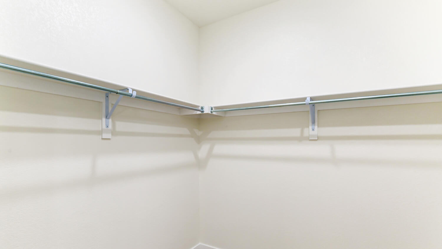 Walk-in closet with built-in shelving located in primary bedroom suite