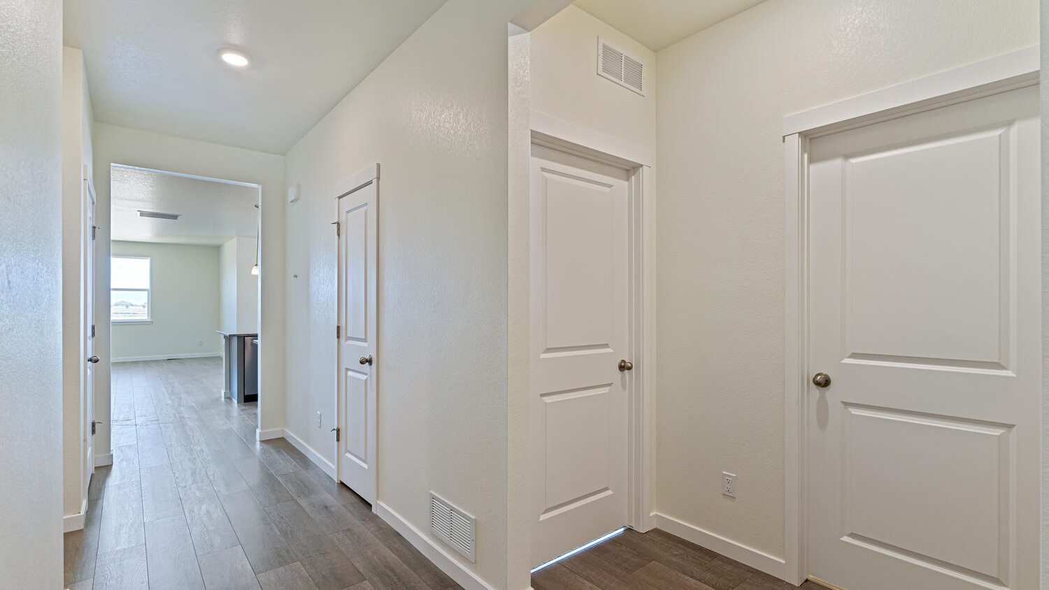 Foyer showing hallway leading to kitchen past the secondary bedroom, secondary bathroom, laundry, and linen closet