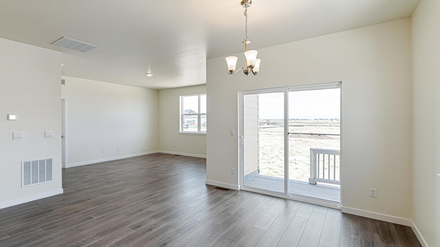 Sliding door in dining nook leading to outdoor covered patio and angle view of great room