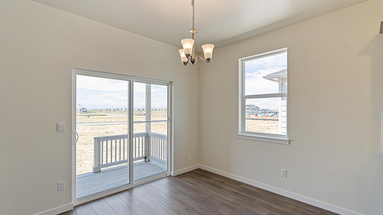 Dining area with suspended lighting, window, and sliding door leading to outdoor covered patio