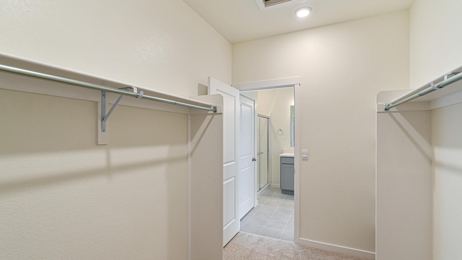 Expansive walk-in closet located in private bathroom with built-in shelving and additional linen storage