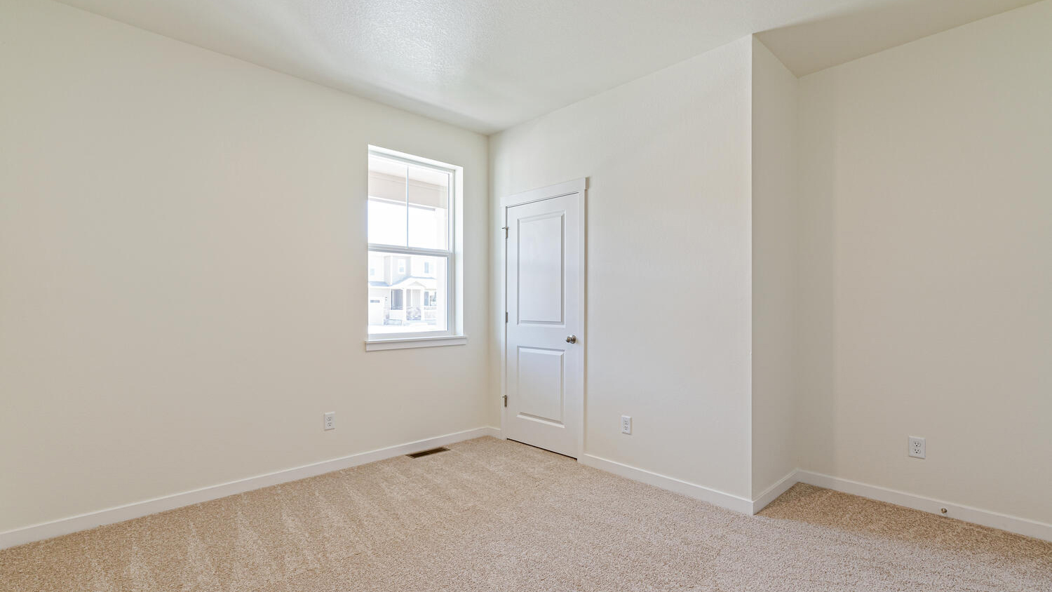 Secondary bedroom showing plush carpeting, window, and door to closet storage