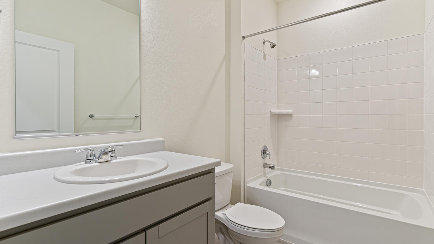 Secondary bathroom shared by two bedrooms with shower/bathtub combo, vanity sink and chrome fixtures