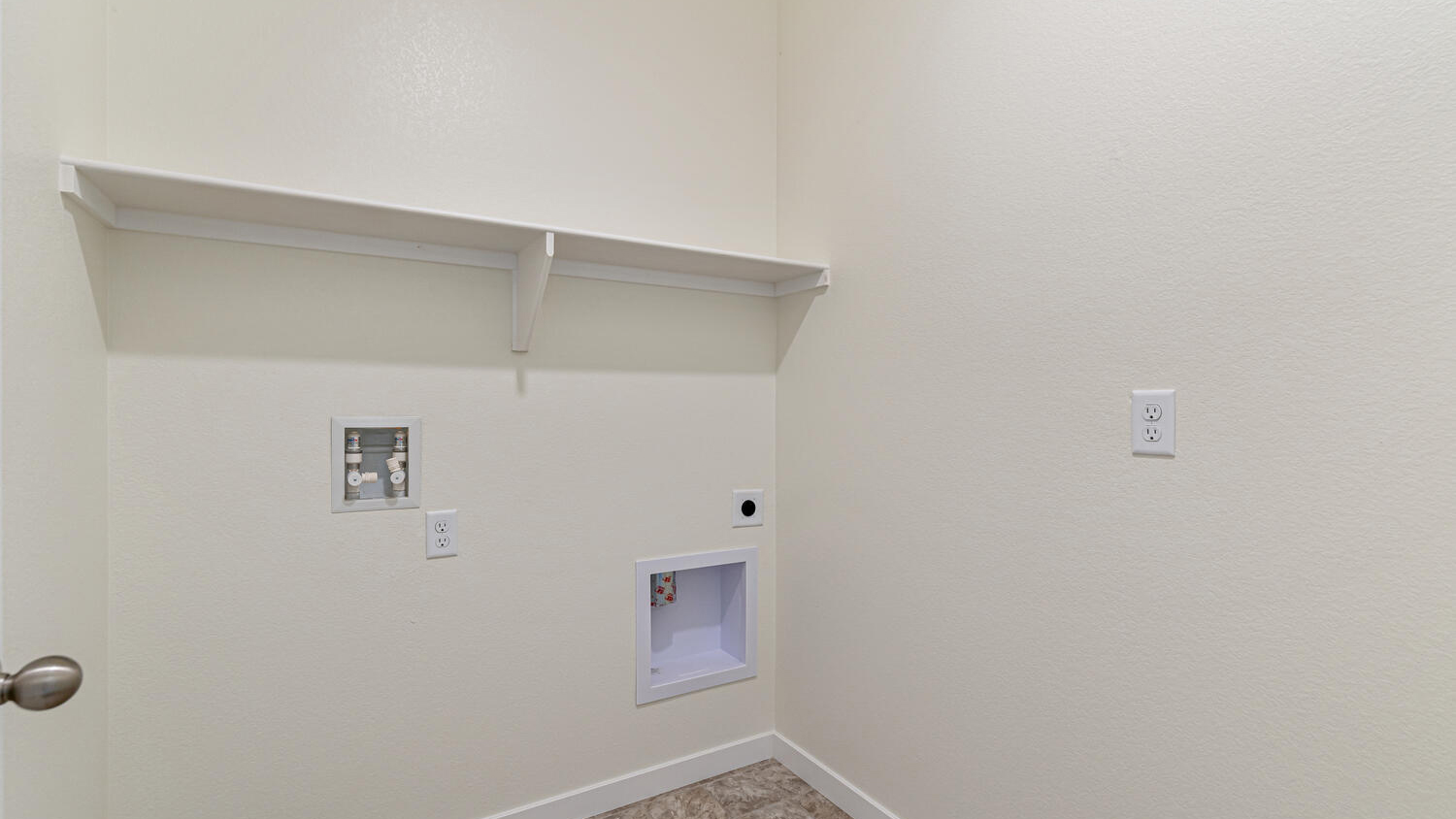 Centrally located laundry room with built-in shelving and full size washer/dryer hookups