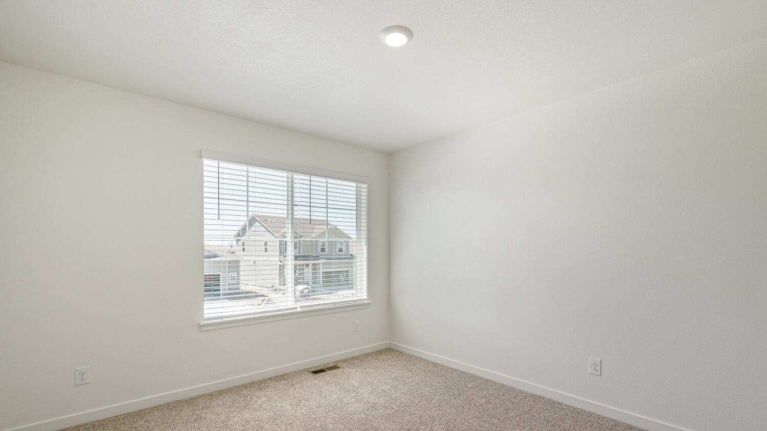 Secondary bedroom near primary bedroom with large window for ample natural light and plush carpeting