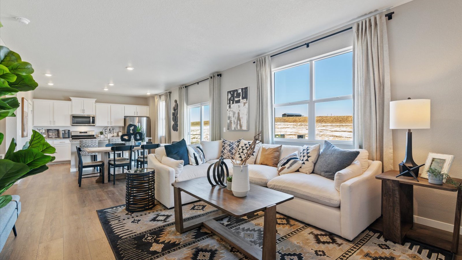 Open concept living room space with large windows in new home in Commerce City, Colorado