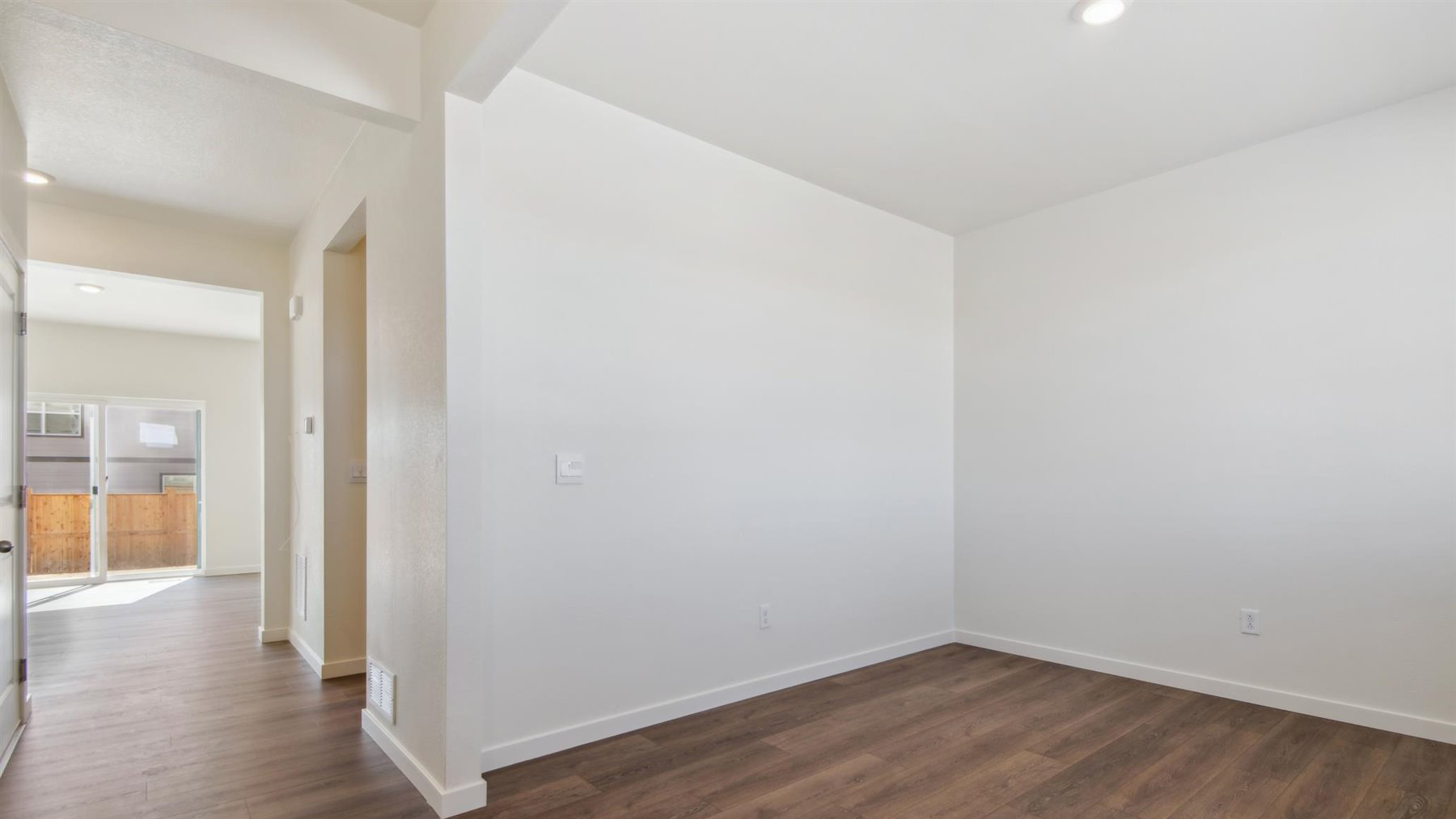 Angle view of study, hallway leading to living area, and opening to powder room, closet, and mechanical room