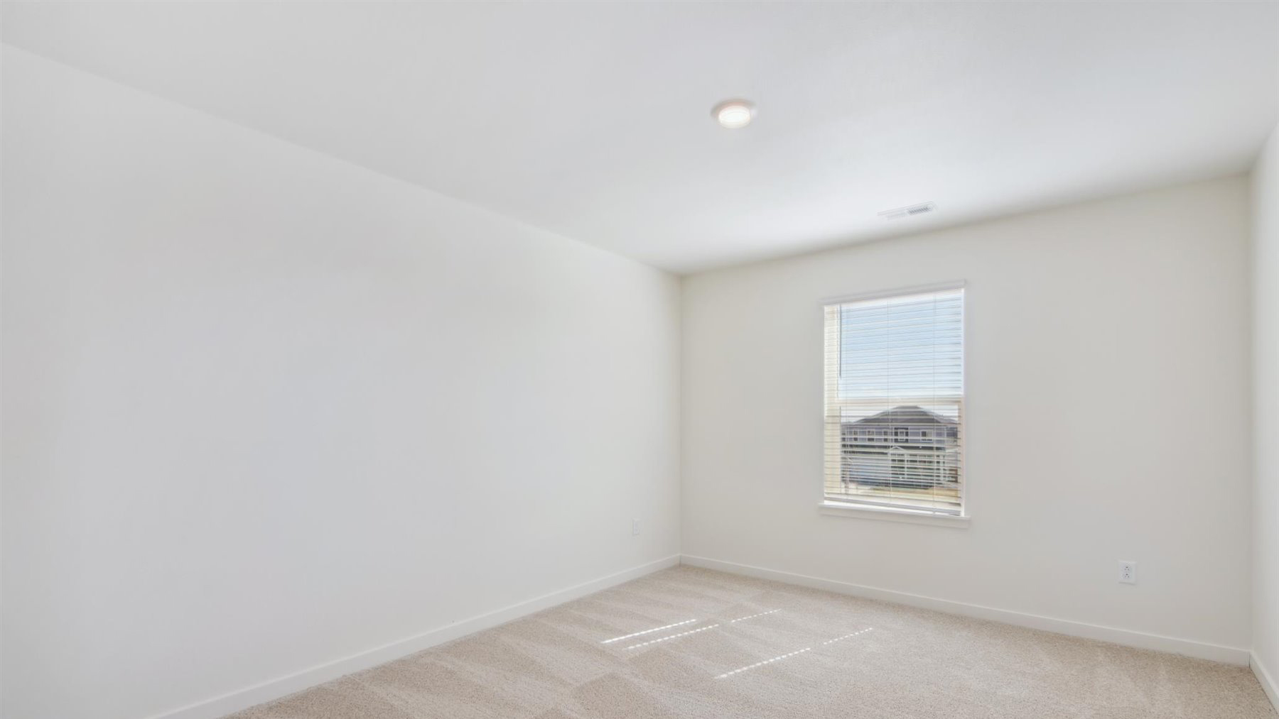 View of loft from top of stairwell on second floor, with plush carpeting and ample LED and natural window lighting