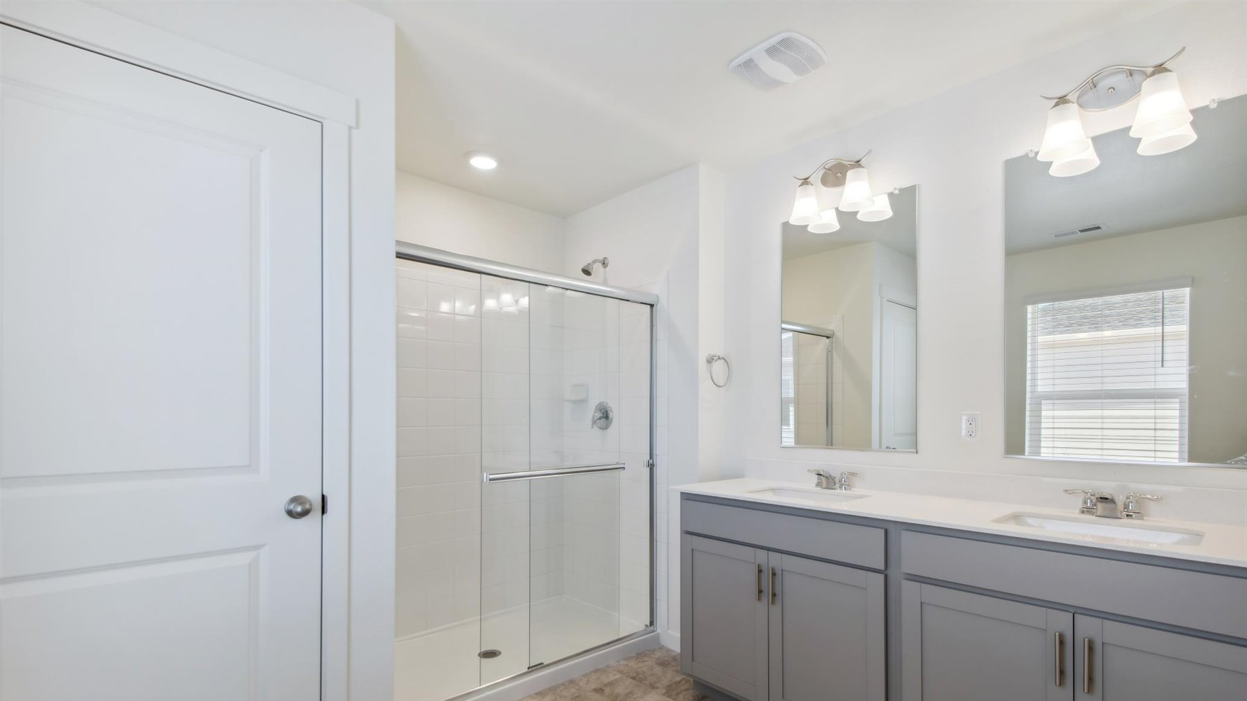 Large private bathroom in primary bedroom suite with linen closet, step-in shower, and dual vanity sinks