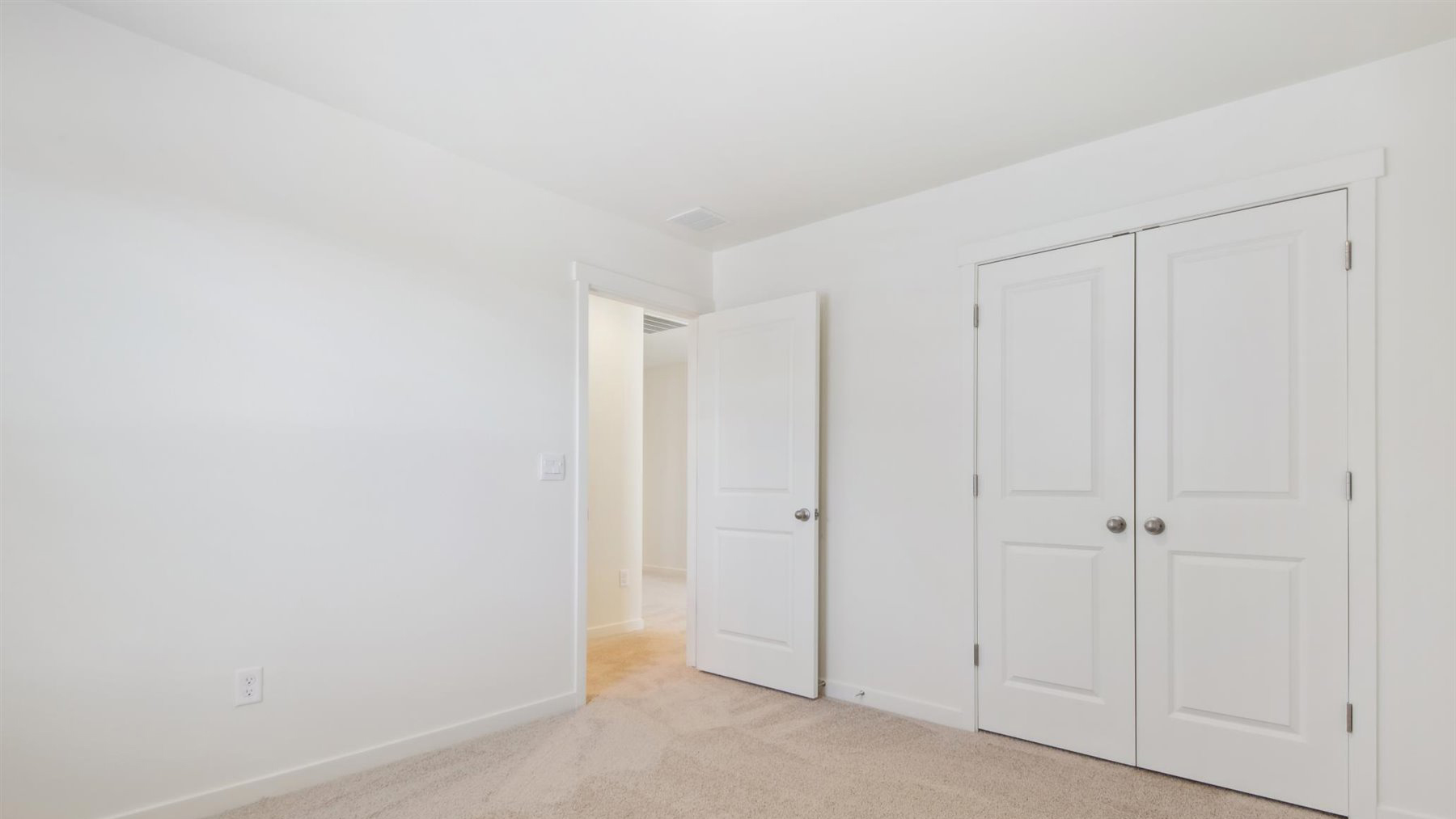 Additional secondary bedroom image showing double door closet and door leading to hallway