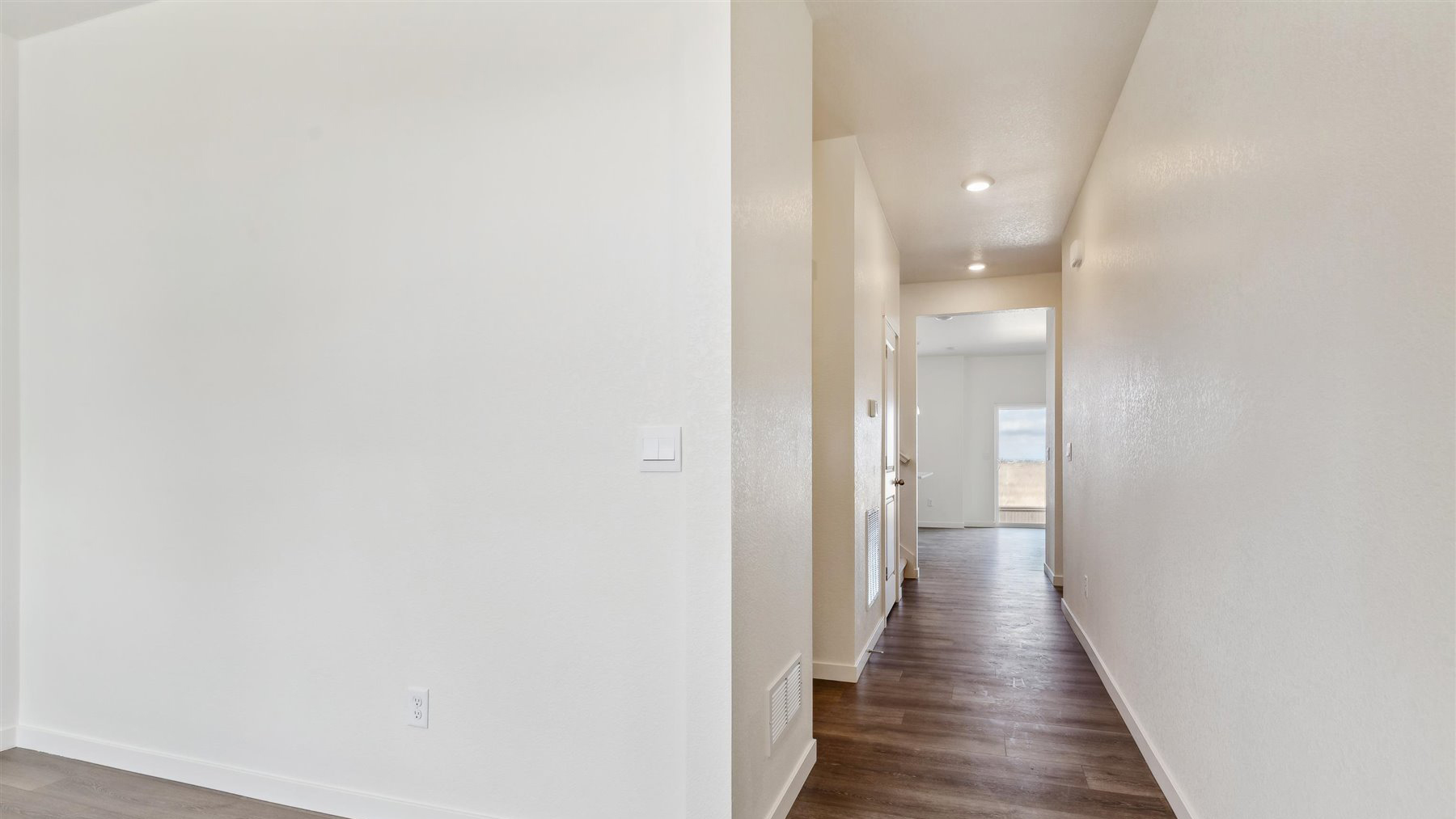 View of study room wall and foyer leading to powder room, stairwell to upper floor, and main living area