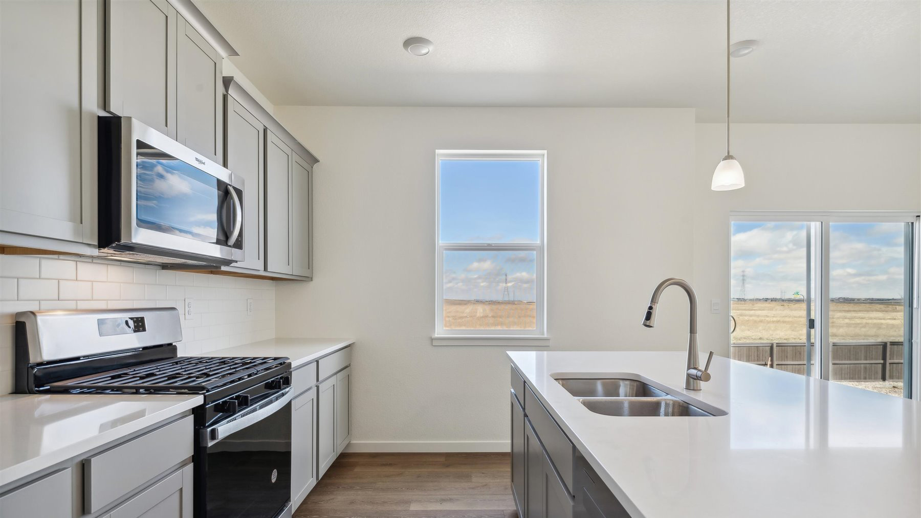 Galley kitchen perspective featuring spacious granite countertops, stinless steel appliances, and ample natural lighting