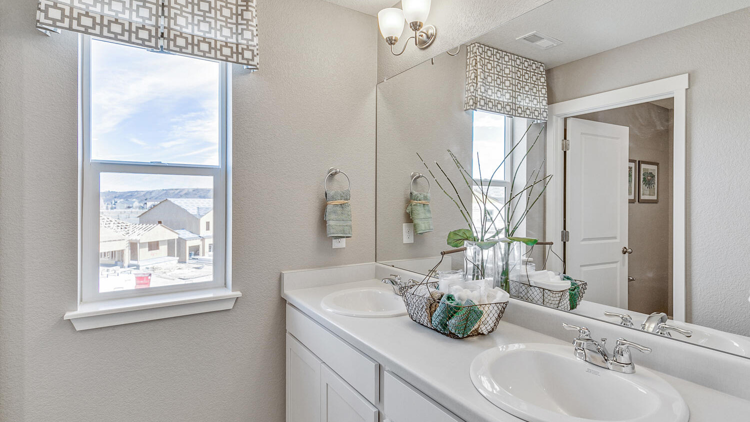Secondary bathroom with dual vanity sinks in new home in Commerce City