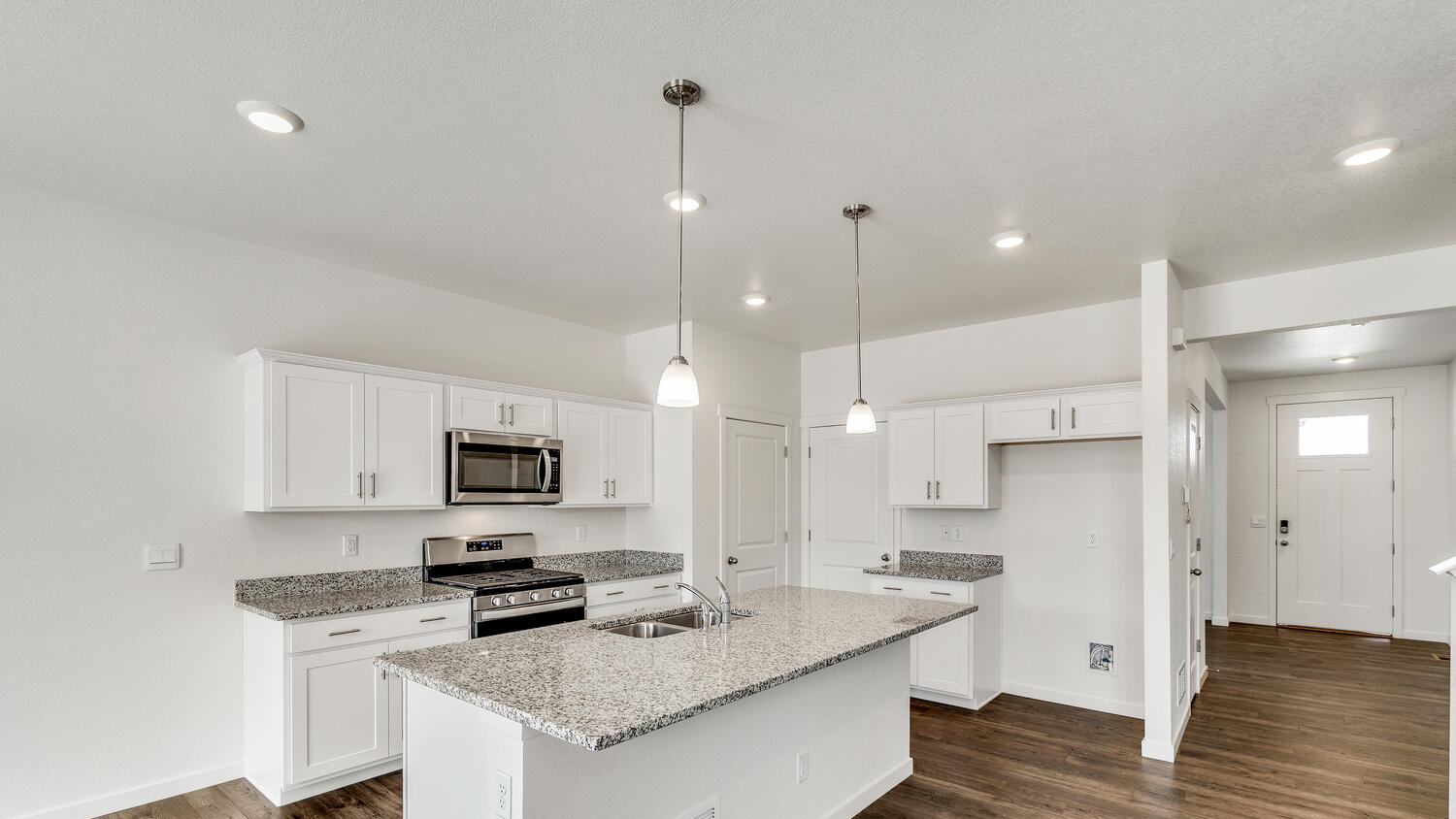 Corner view of kitchen with center island, pantry, premium cabinetry, and stainless steel appliances