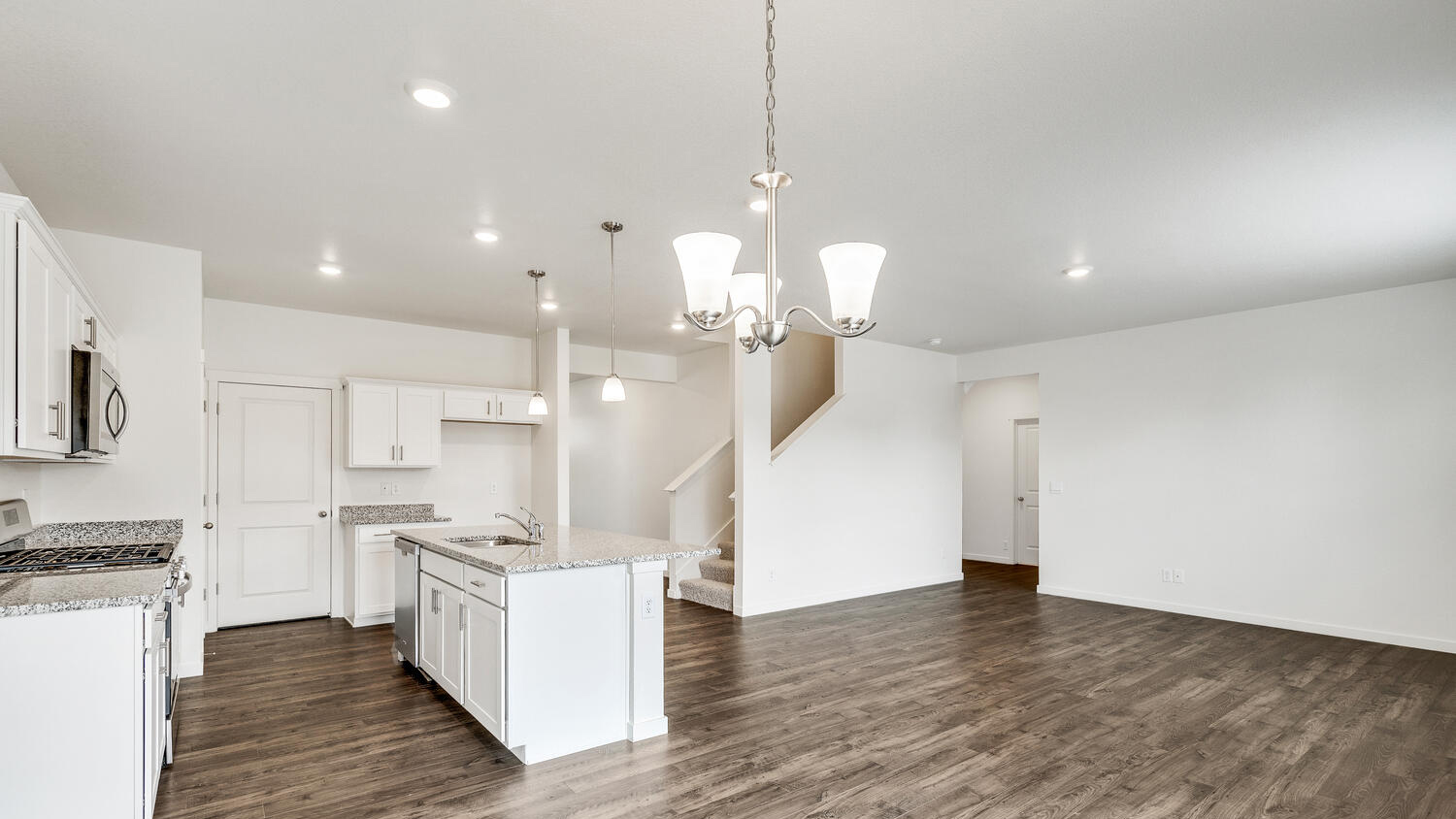 Integrated dining nook, kitchen, and great room, featuring ample lighting from windows and energy efficient LED lighting
