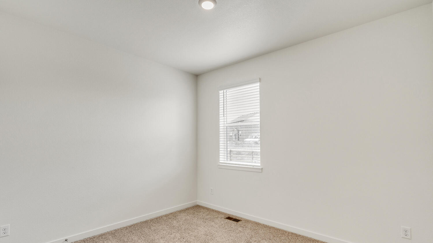 Plush carpeting, window, and LED lighting in secondary bedroom near bathroom on main floor