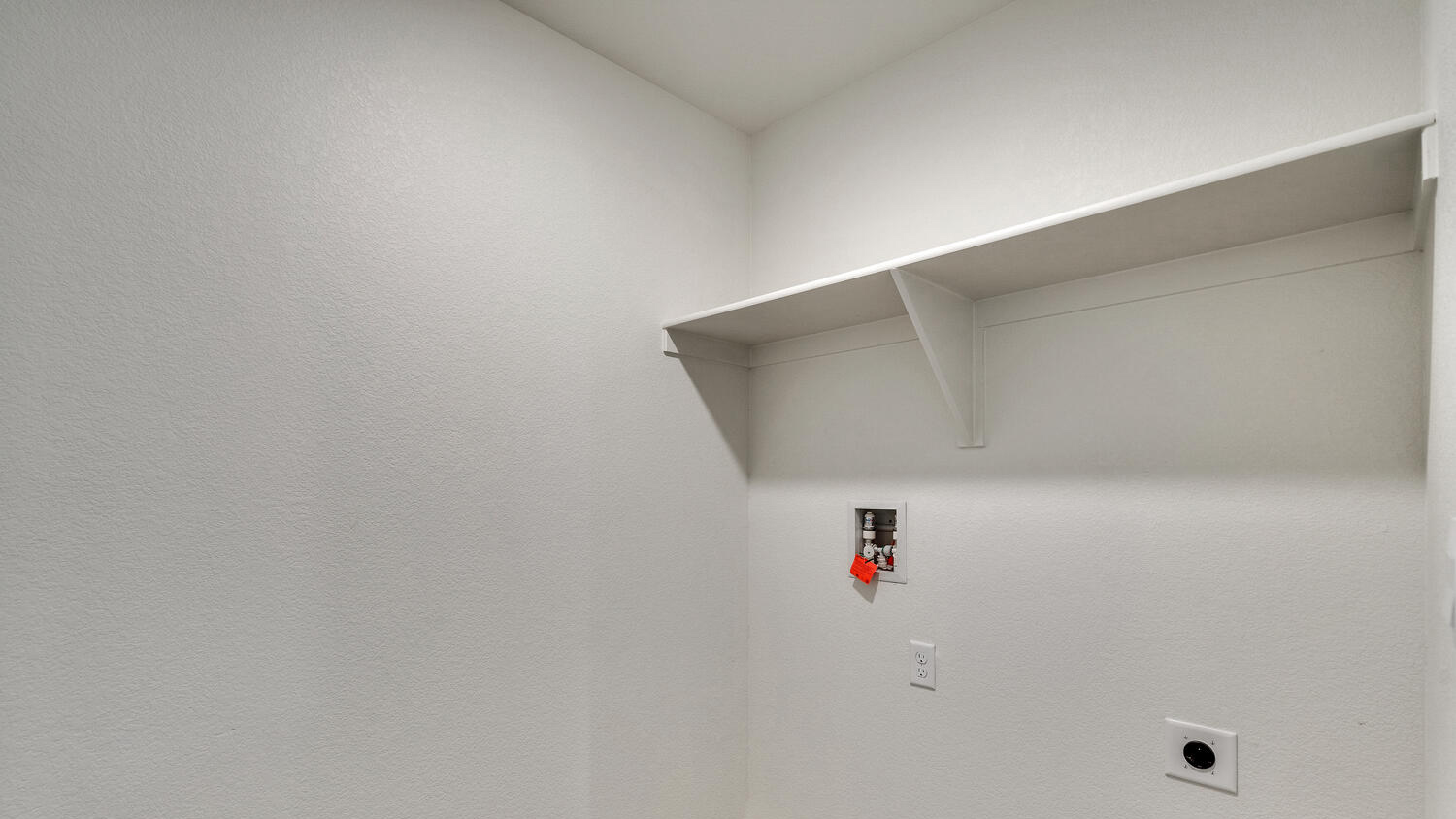 Laundry room located at top of stairwell near upper floor living area with full size washer/dryer hookups