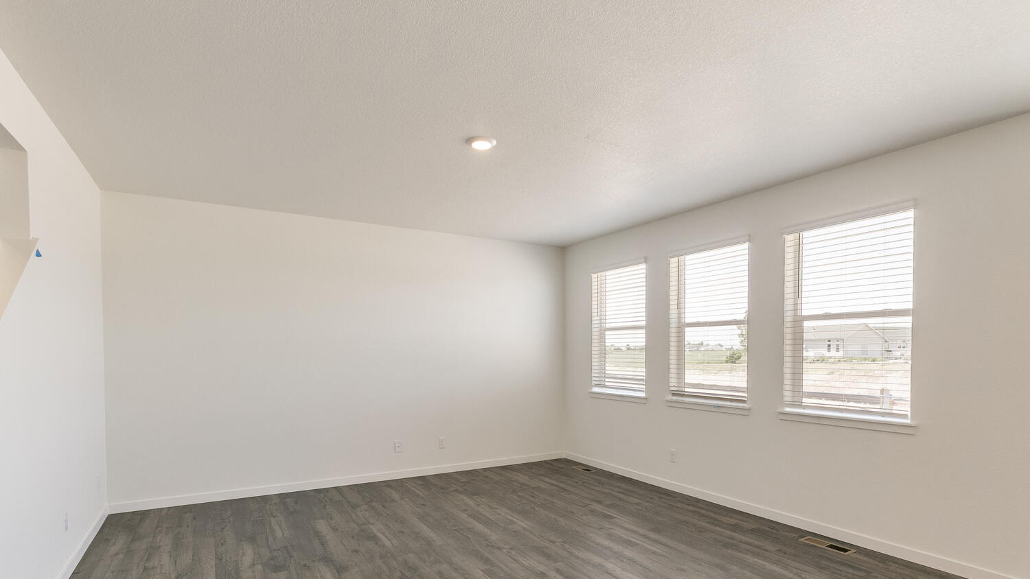 Great room with ample natural lighting from three large windows and energy efficient LED light fixtures