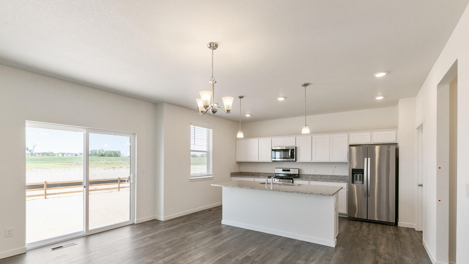 Kitchen with center island connected to dining nook with sliding door leading to outdoor patio