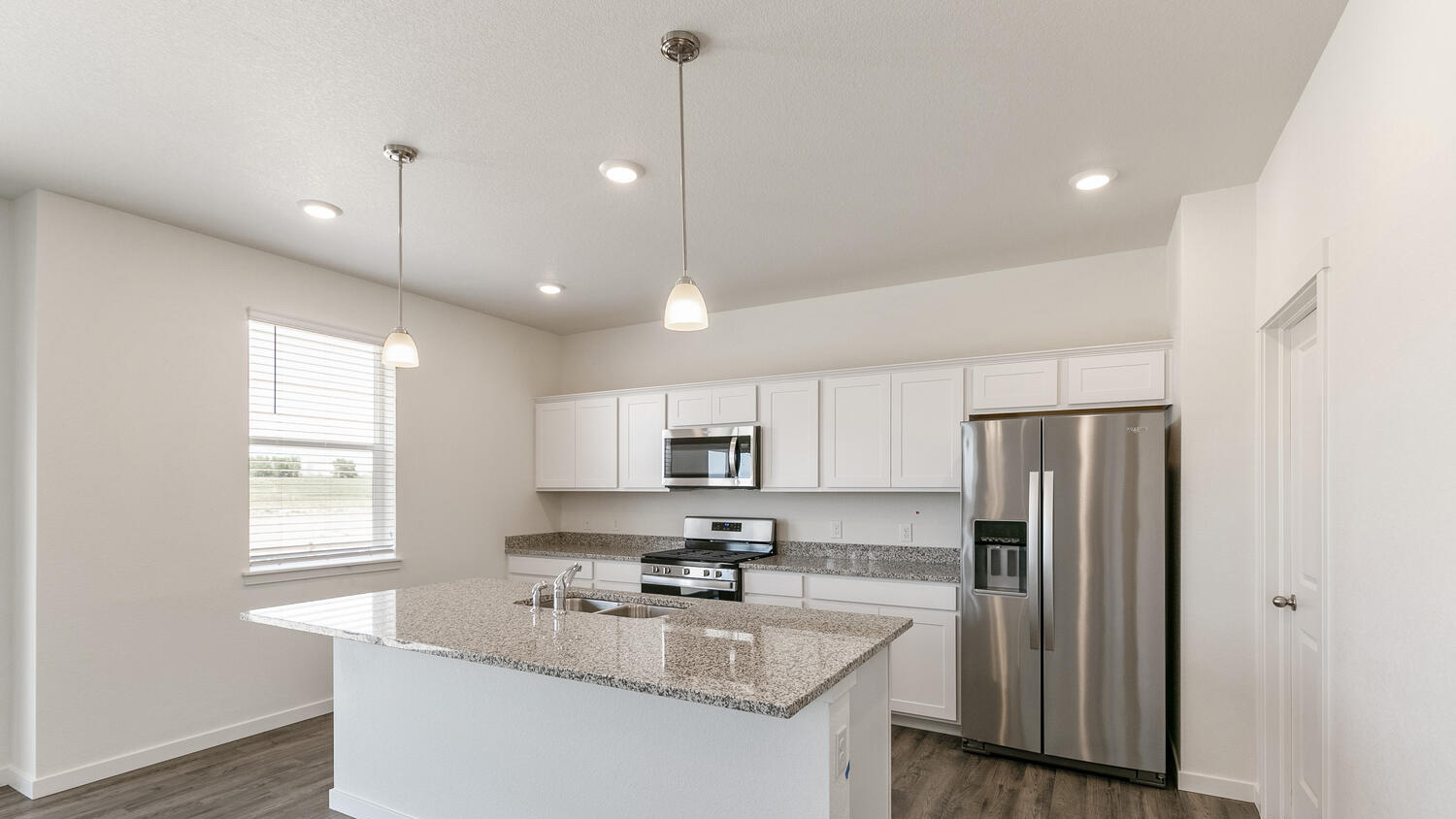 Functionally laid out kitchen with ample lighting and cabinet space, and walk-in pantry for additional storage