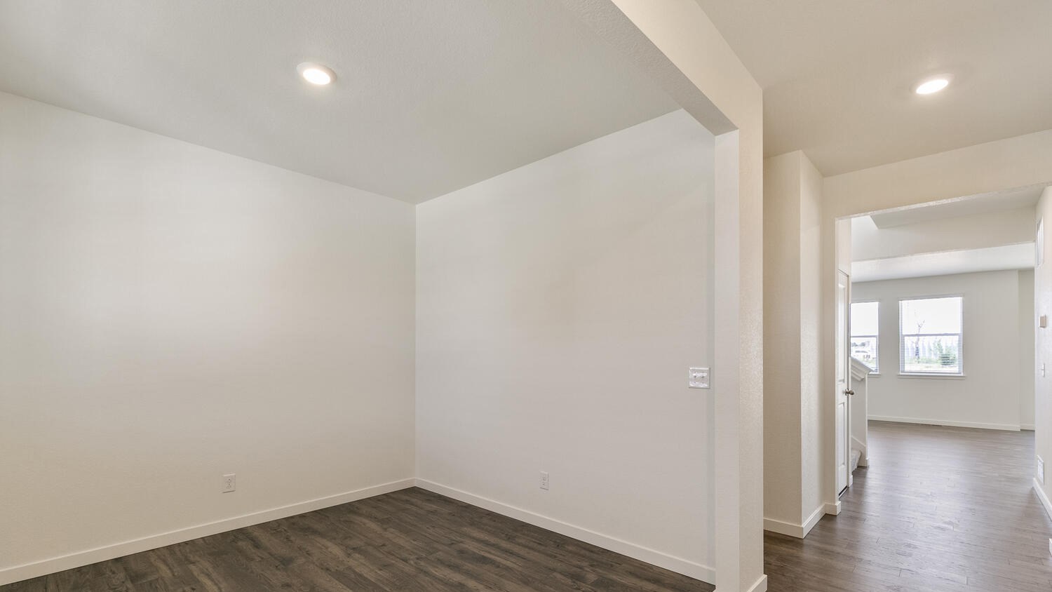 View of large open study room from foyer leading to powder room, stairwell, and main living area