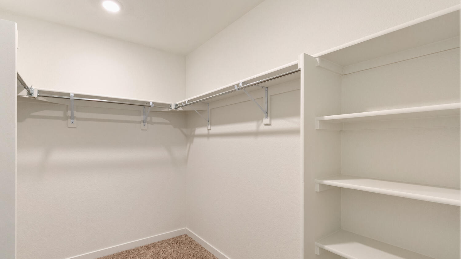 Spacious walk-in closet in main bedroom with built-in shelving and linen storage