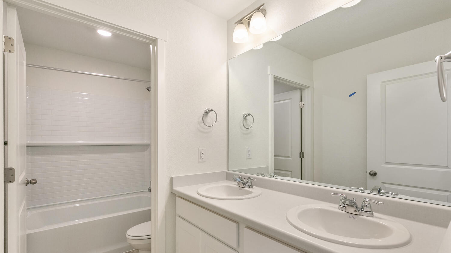 Split secondary bathroom near stairwell and across from primary bedroom suite with double sinks