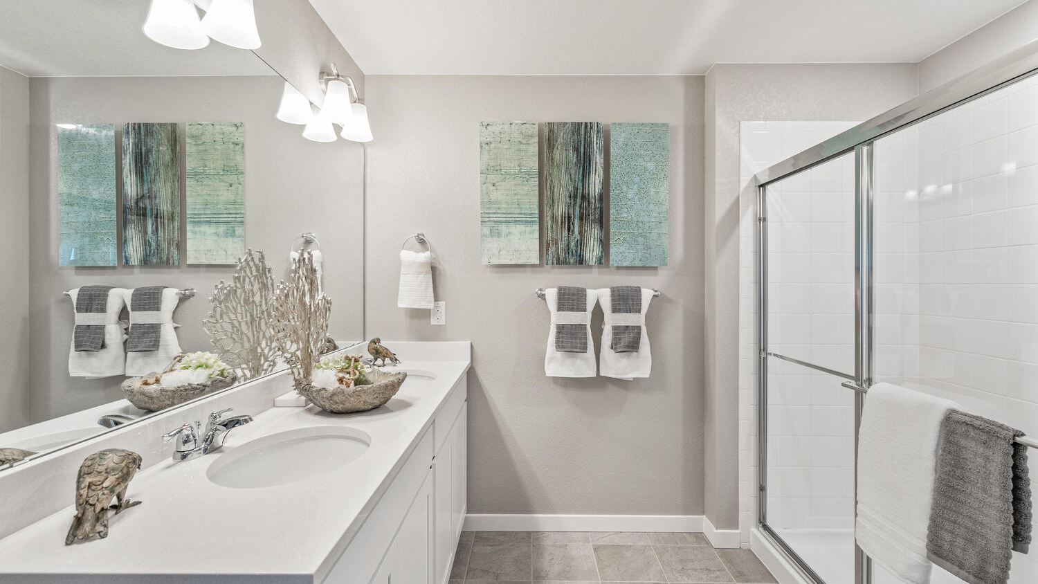 Private attached bathroom with dual sink vanity at Settler's Crossing community in Commerce City, Colorado