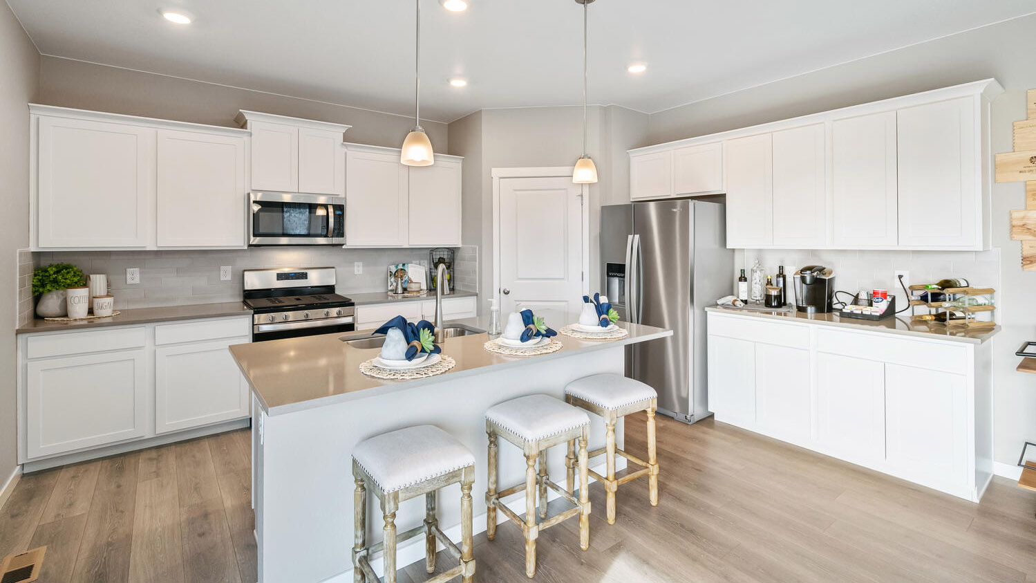 Angle view of kitchen featuring ample pantry and cabinet storage and center island with pendant lighting