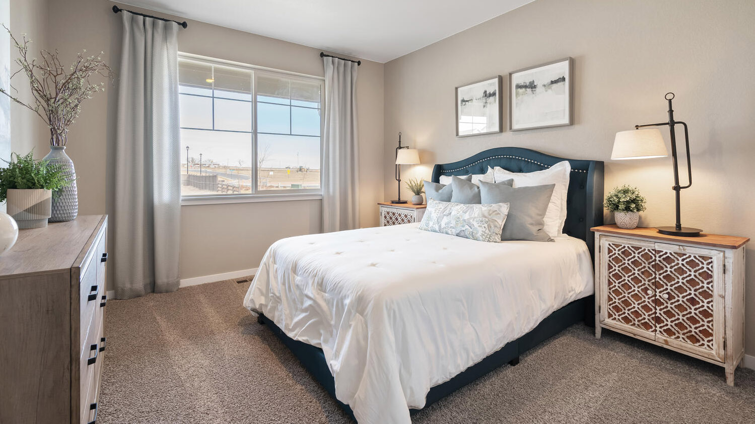 Main floor bedroom near front entry with large window for ample natural light and plush carpeting