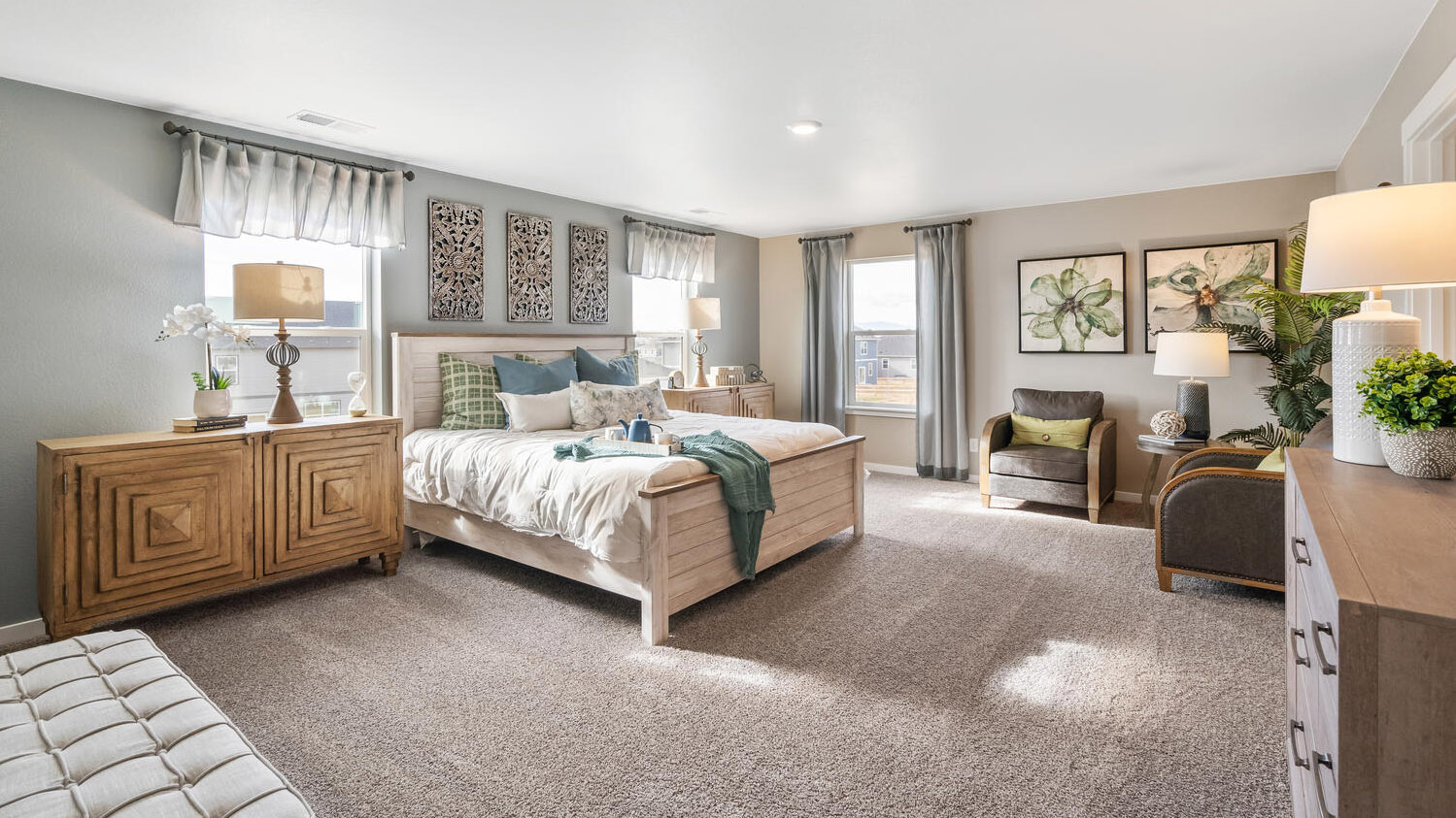 Generously sized primary bedroom suite featuring three windows for ample natural light and plush carpeting