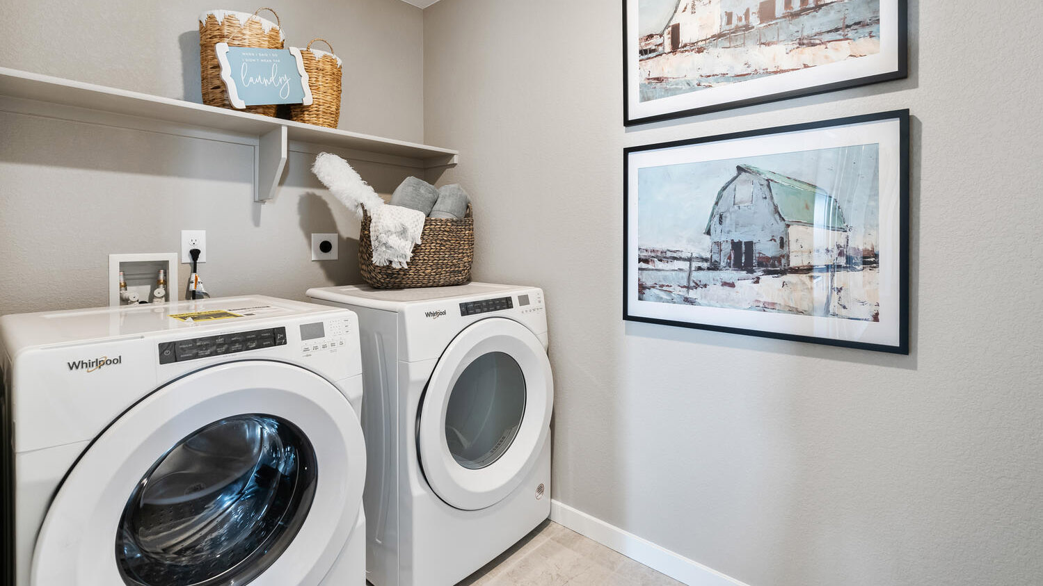 Laundry room near loft space on upper floor with built-in shelving and full size washer/dryer hookups
