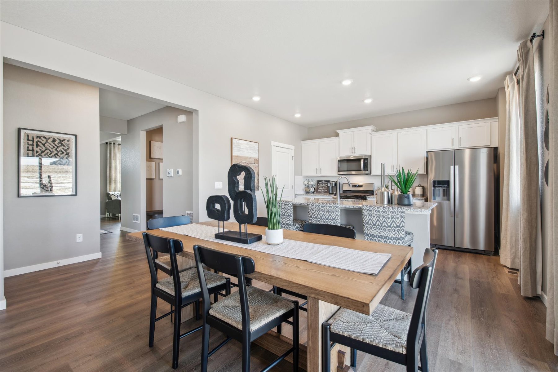 Alternate view of kitchen and dining nook with open wall leading to hallway and entryway