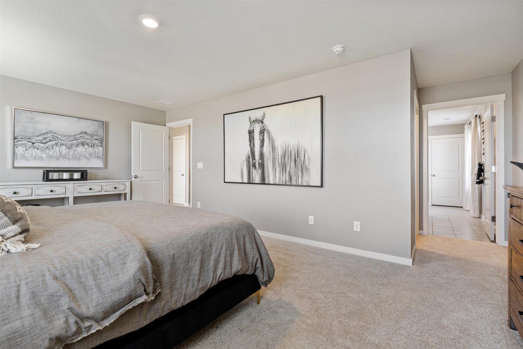 Another primary bedroom view showing large wall space and private bathroom
