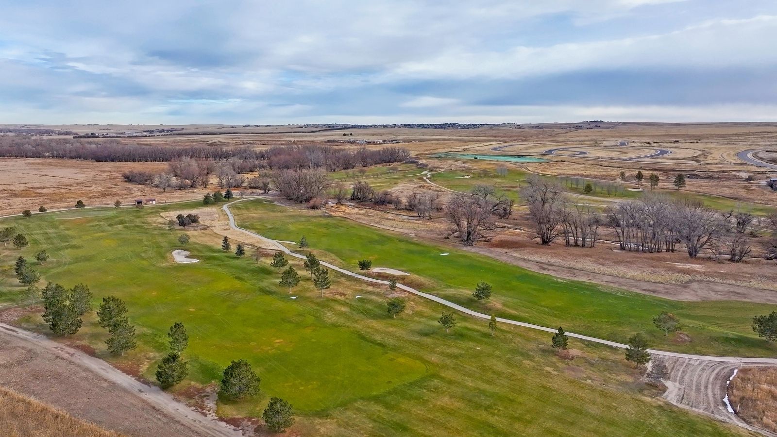 Nearby landscape of grass, trees, and small roads around Denver's Spring Valley Ranch
