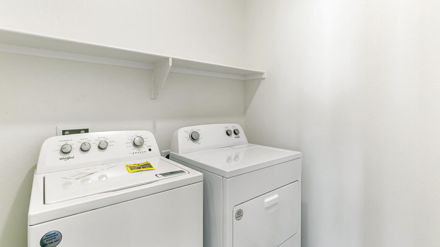 Centrally located laundry room with full washer/dryer connections and built-in shelf