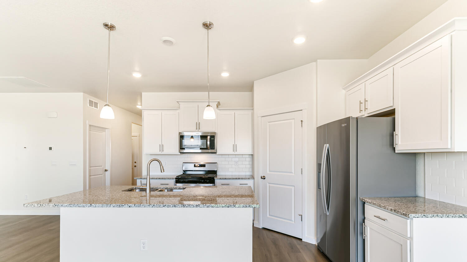 Front view of open kitchen with plenty of counterspace and cabinet and pantry storage