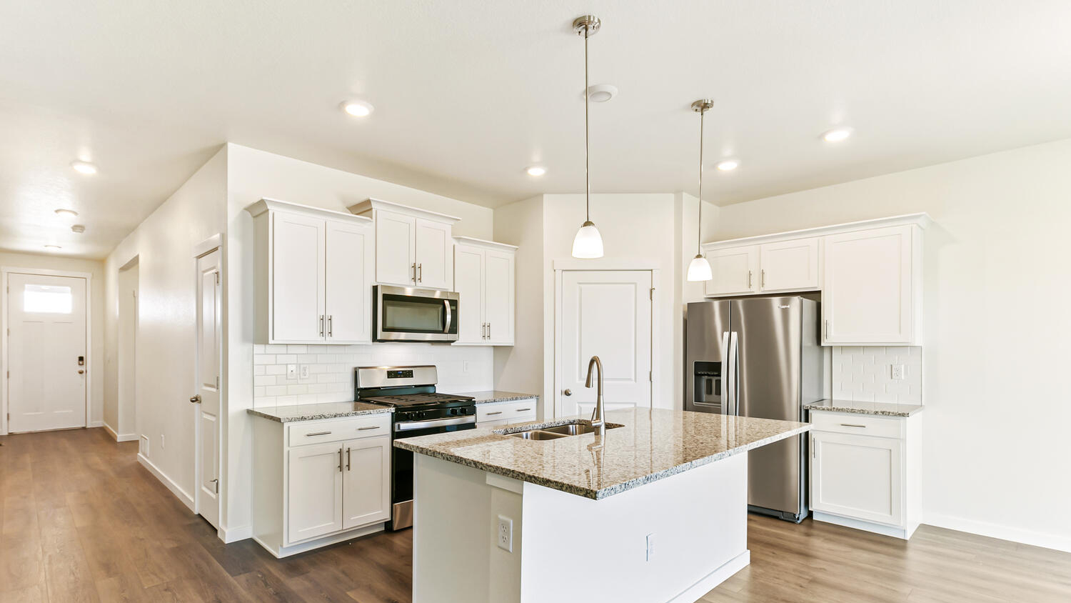 Kitchen featuring spacious island, designer cabinetry, corner pantry, and stainless steel appliances
