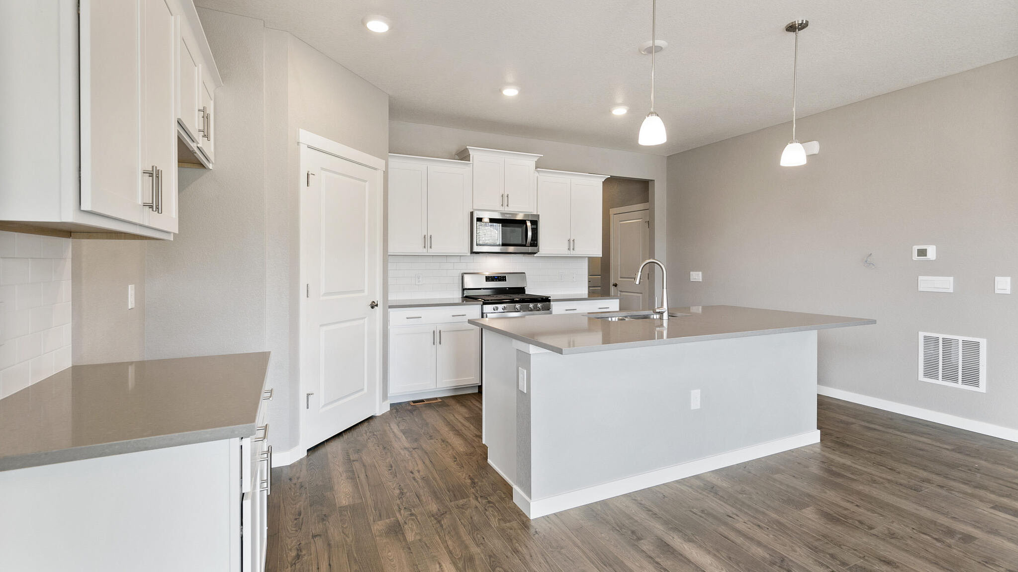 large kitchen island and walk in pantry of new construction home elizabeth, co