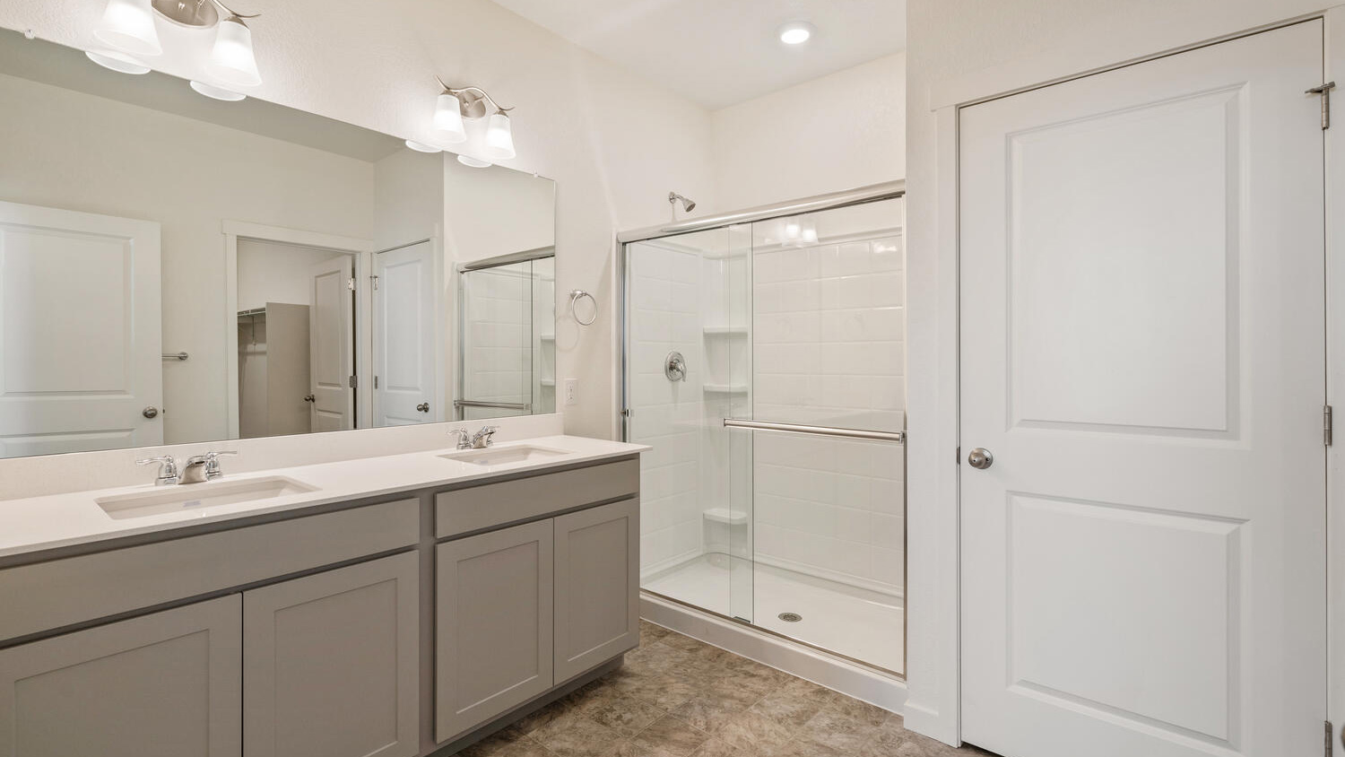 Step-in shower, dual sinks, ample counterspace and cabinetry in private bathroom