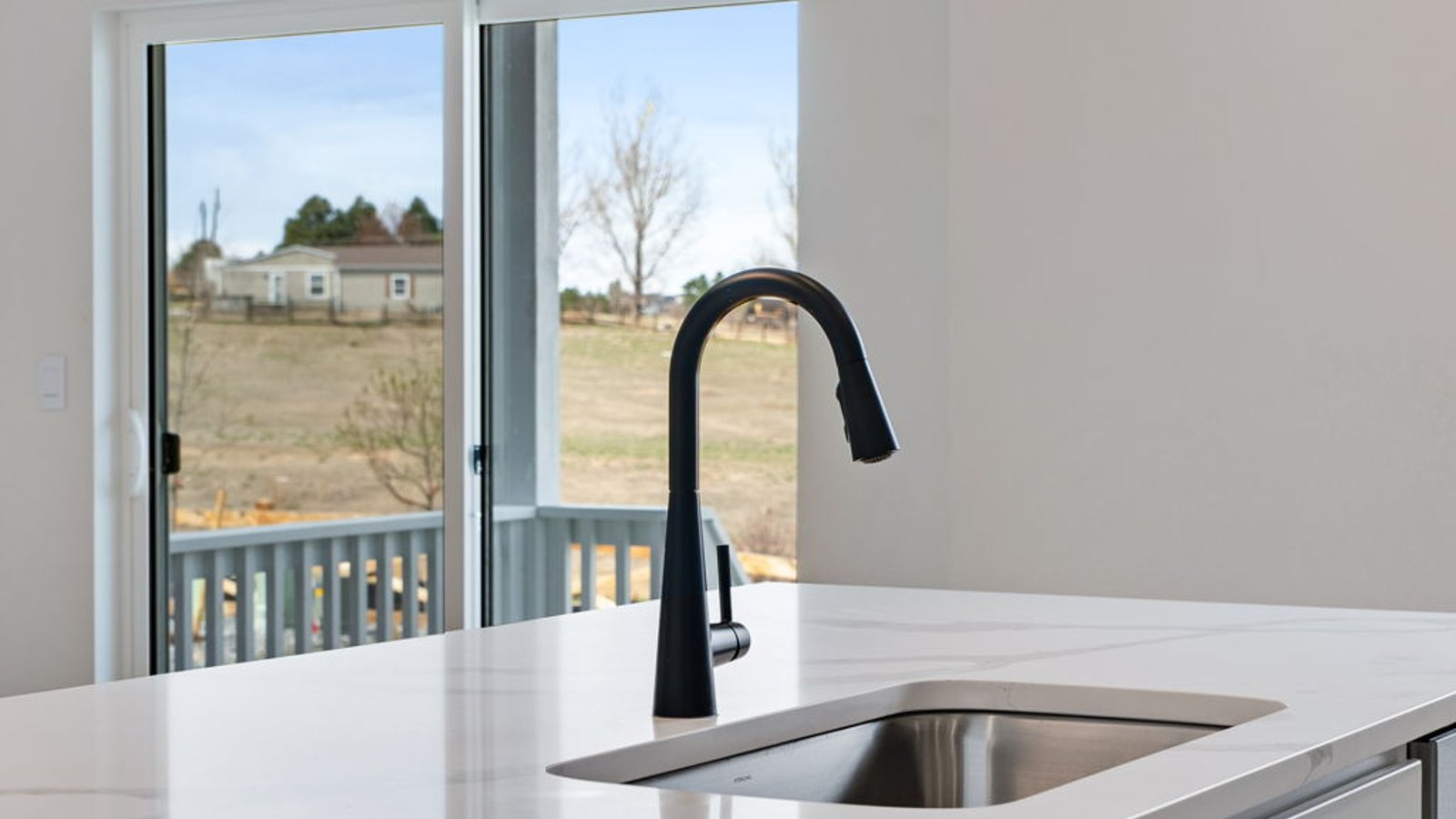 quartz countertops and black faucet in modern kitchen by d.r. horton