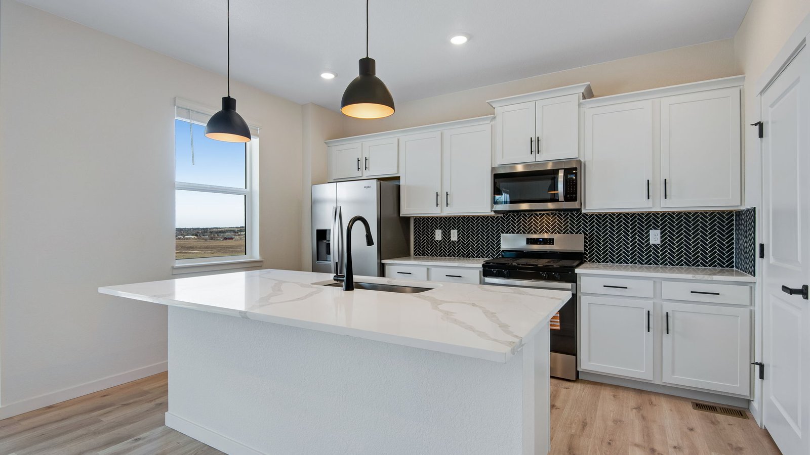 modern kitchen with black pendants in new home elizabeth, co