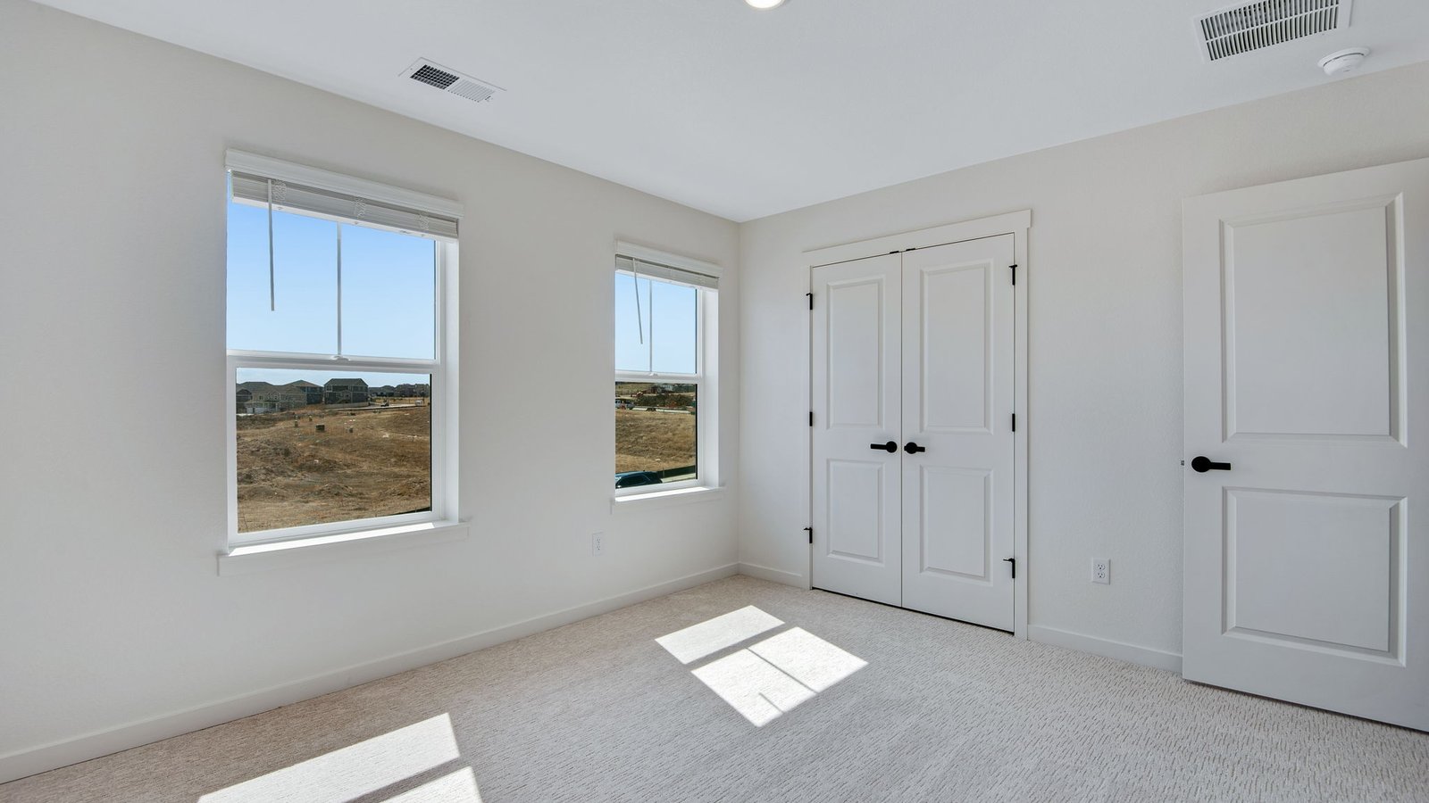primary bedroom with large windows in new spring valley ranch home