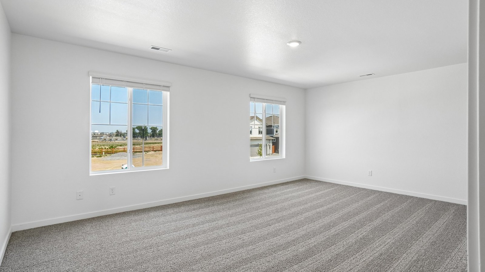 Spacious bedroom with large windows in new home at Spring Valley Ranch community