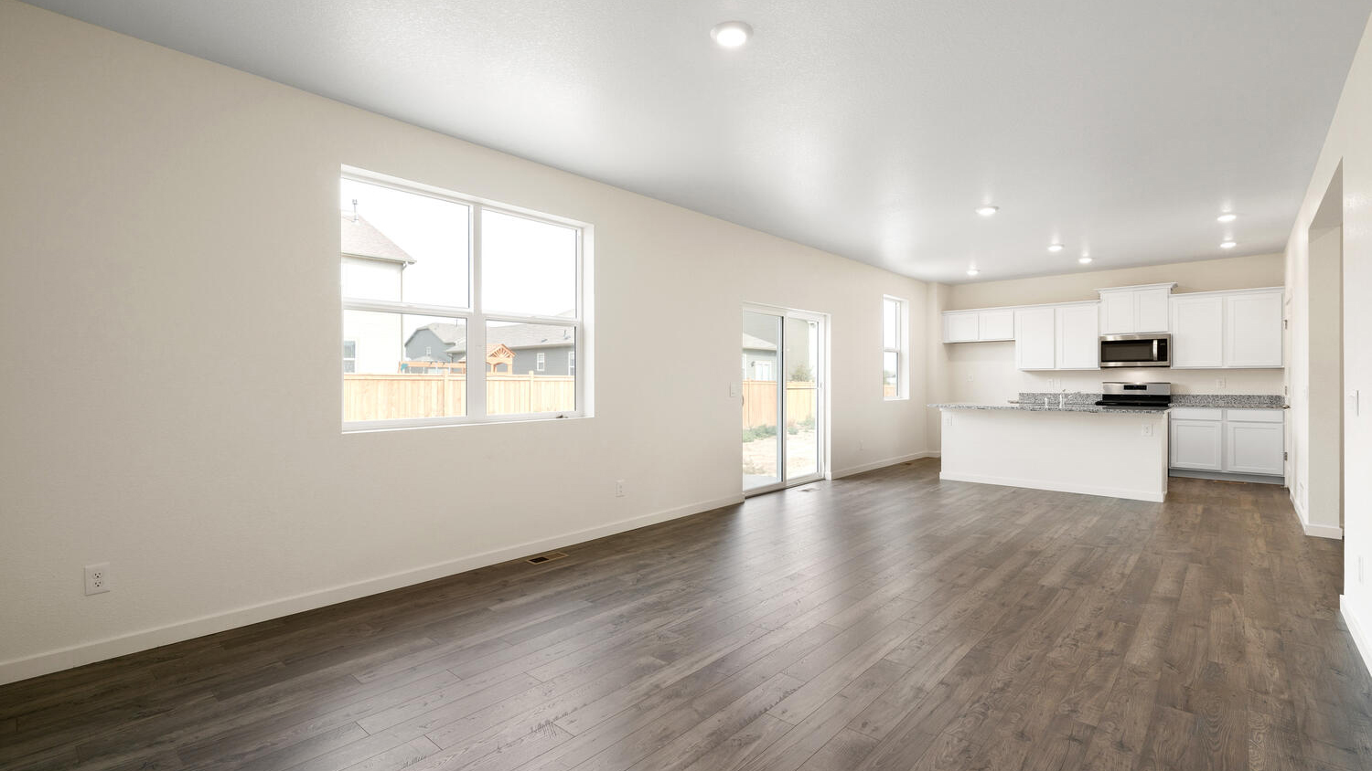 Connected great room, dining nook, outdoor patio access, and kitchen