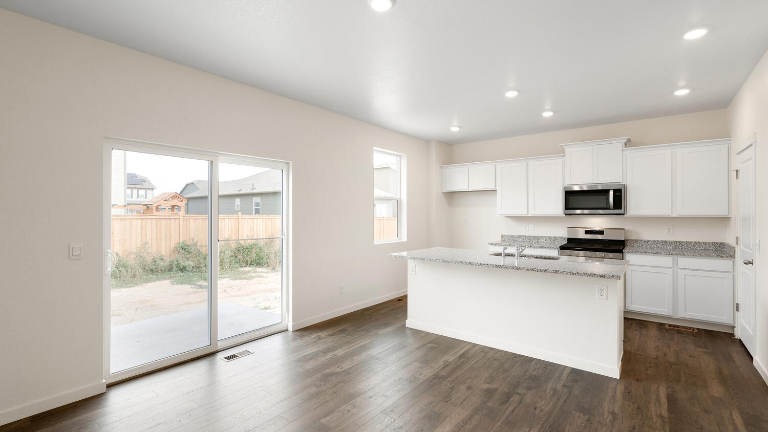 Sliding door with outdoor patio access in dining nook and open kitchen