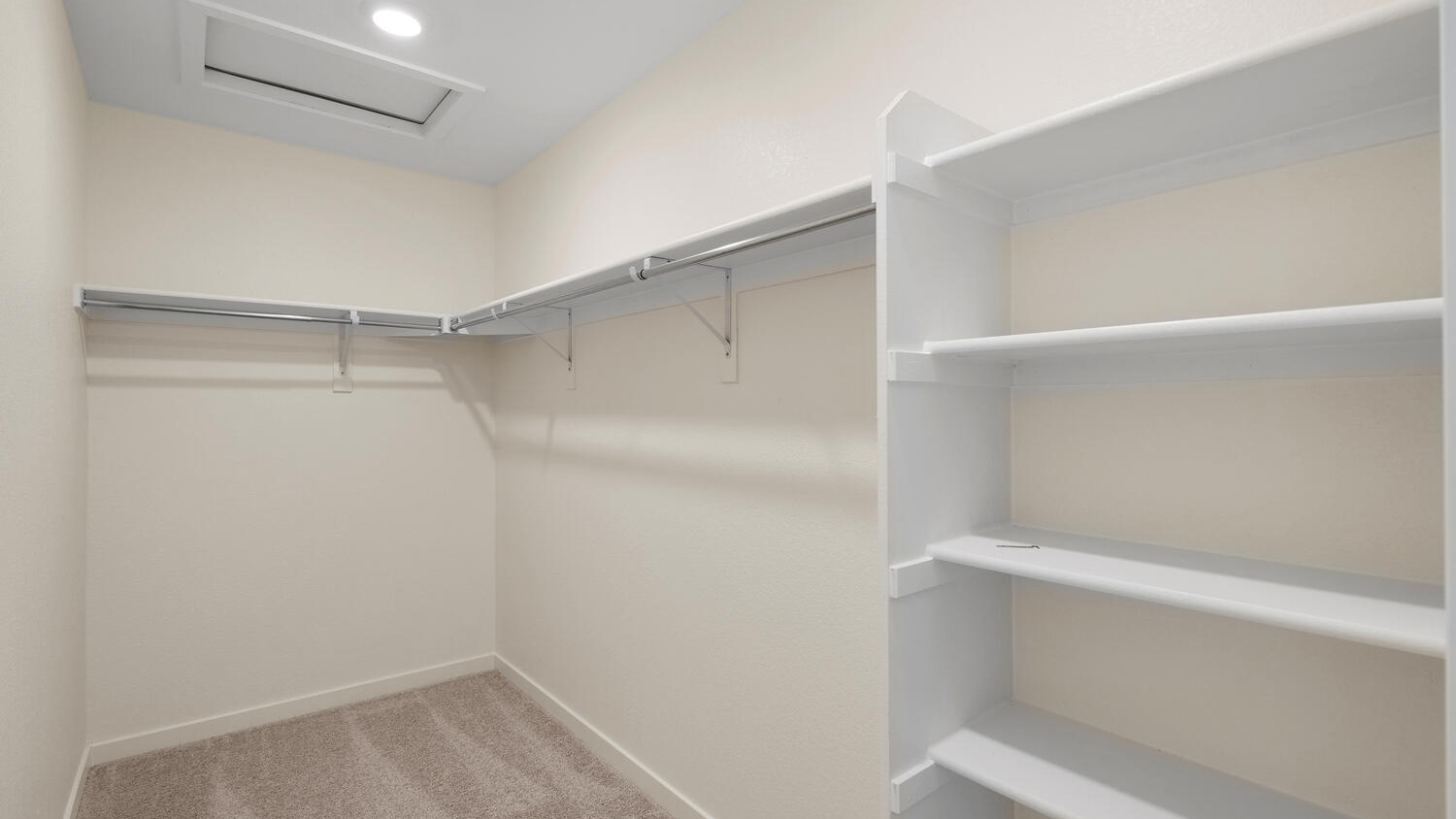 Generously sized walk-in closet in primary bedroom suite with build-in shelving
