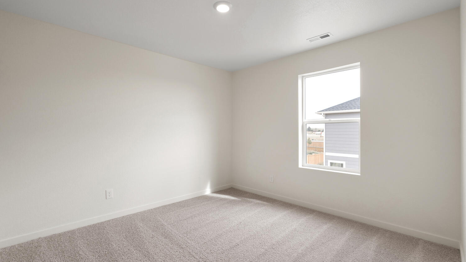 Secondary bedroom near laundry room with plush carpeting, closet storage, and energy-efficient LED lighting