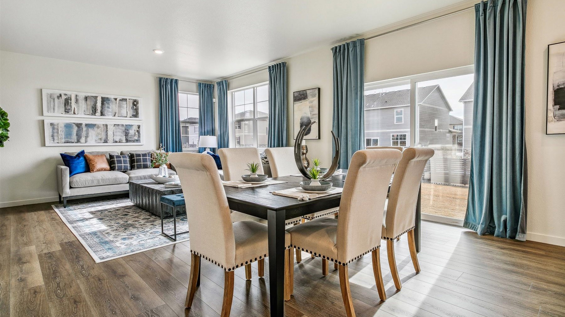 Dining nook integrated with great room showing ample natural light from large windows and sliding patio door