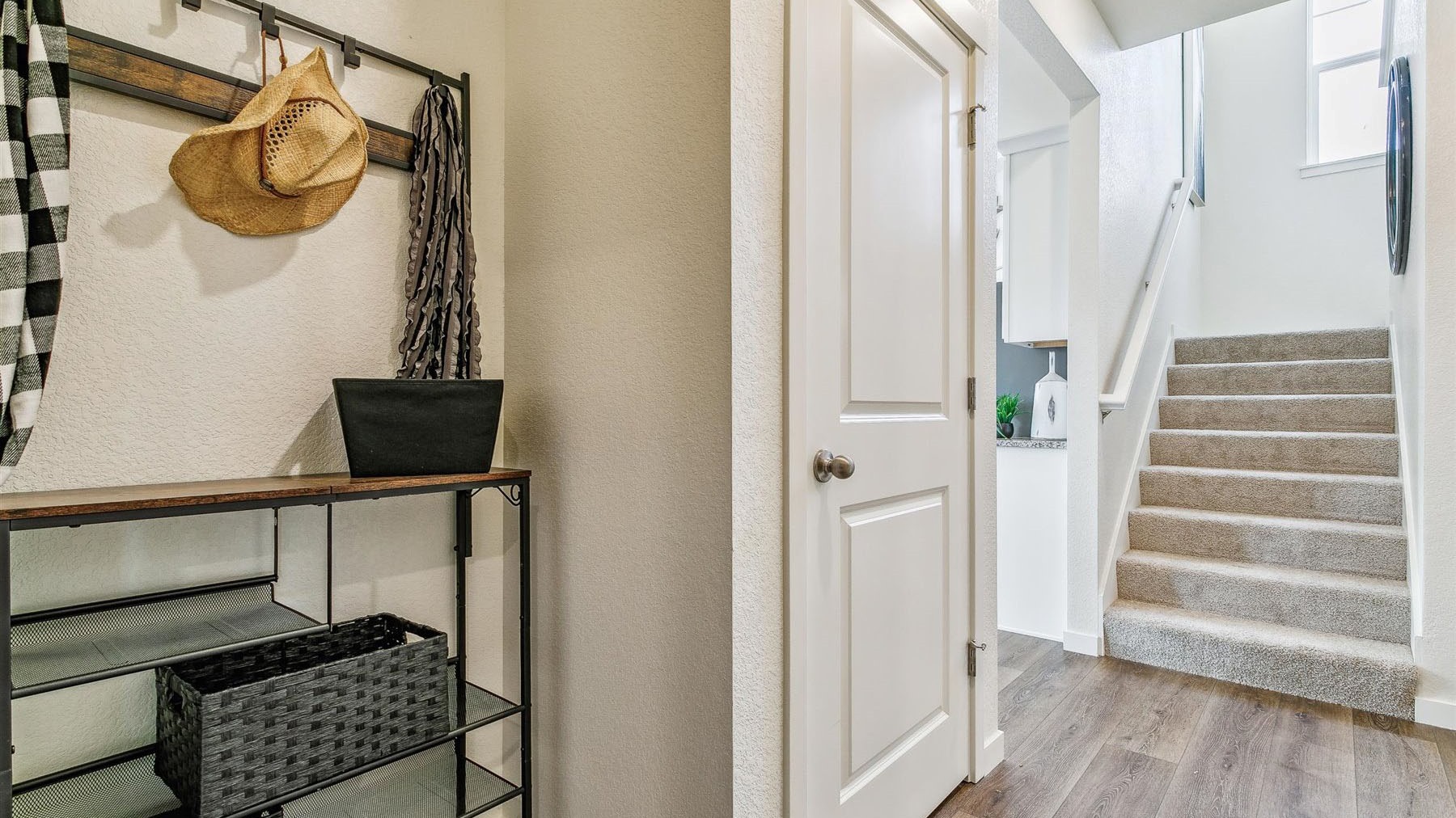 View of coat closet in hallway on main floor, stairwell leading to upper floor